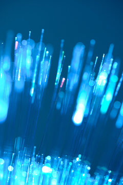 Vertical blue fiber optic lines macro shot with beautiful glowing bokeh dots.