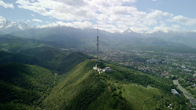 6.6.2026 Almaty.Kazakhstan. Aerial view of Kok Tobe hill with Almaty television tower and snowy mountains background, Kazakhstan