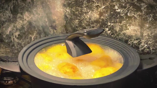 A close-up shot of yellow potatoes boiling in a simmering pot under a glass lid on a stove, perfect for culinary blogs, recipe promos, and home cooking videos.