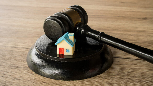 Miniature house model sitting on top of a judge sound block real estate auction