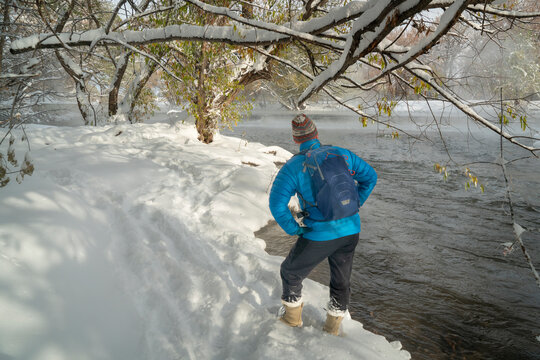 senior male hiker on a shore the Poudre River in Fort Collins, Colorado - foggy fall scenery with a fresh snow