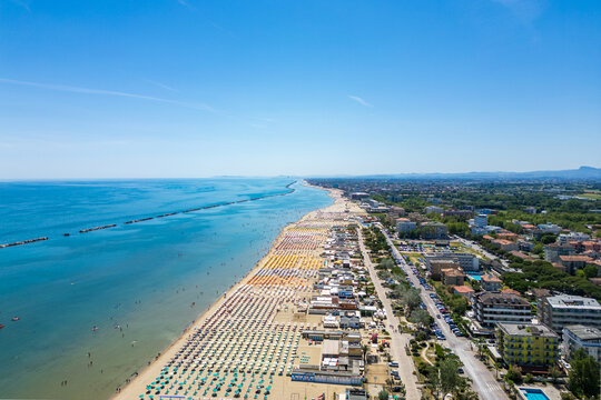 Cesenatico, Italy, June 8, 2026: Aerial view of the coastal landscape, featuring the iconic skyscraper, busy beach umbrellas, and the Adriatic Sea on a sunny summer day.