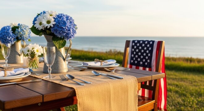 Patriotic outdoor dining table setup with hydrangeas and american flag decor at sunset by the coast