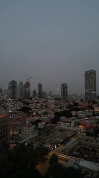 aerial view of neve tzedek district and modern skyline in tel aviv at dusk pan right drone shot