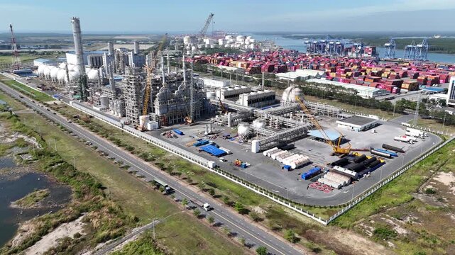 aerial view, industrial port, top down shot, cargo harbor, shipping terminal, container park, dock area, quay side, vessel berthed, crane row, port machinery, loading dock, freight yard, storage yard,