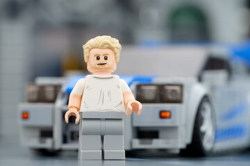 Naklejka premium Tambov, Russian Federation - August 21, 2025 Portrait of a Lego Brian OConner minifigure near his Nissan Skyline GT-R (R34) car.
