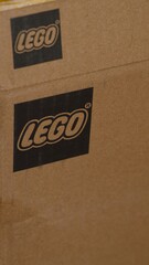 Naklejka premium Tambov, Russian Federation - June 03, 2026 A close-up shot of a cardboard box featuring the printed black Lego logo.