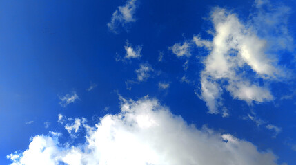 Obraz premium Scenic view of fluffy white clouds against a vibrant blue sky, perfect for nature, weather, environmental, and outdoor-themed projects.