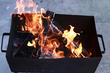 Fototapeta premium Outdoor brazier with burning wood and bright orange flames