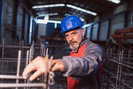 Construction workers in concrete factory, senior man and woman at job.
