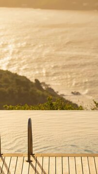Vertical video: Panning camera showing infinity pool, wood deck and rails for reframing at sunset