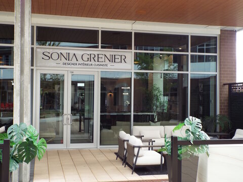 Gatineau, Quebec, Canada &ndash; May 12, 2026: The "Sonia Grenier"  interior designer storefront features a glass entrance and comfortable outdoor patio seating at 20 All&eacute;e de Hambourg Local 138.