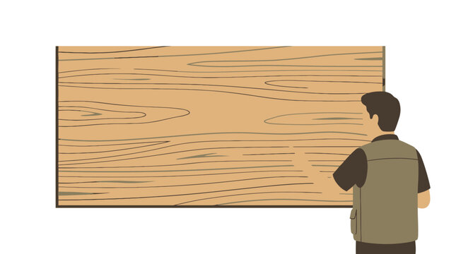 A male carpenter inspecting a wooden board surface.