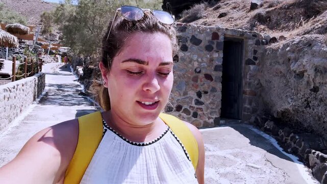 Female vlogger walking at red beach in santorini, greece