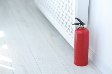 Obraz premium One red fire extinguisher on floor indoors, space for text