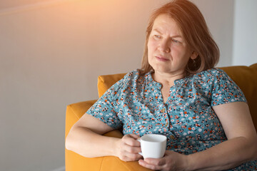 Obraz premium Lady With Thoughtful Expression. Woman Looks Softly While Holding Cup. Woman Gazes Gently As She Holds Her Steaming Drink. Reflective Woman Gently Gazes While Holding Cup In Her Hands With Care
