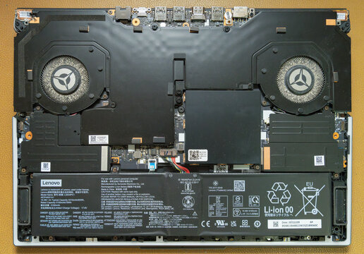 Open laptop internals showing dusty fans and complex circuitry, illustrating potential overheating issues needing professional hardware maintenance or repair service