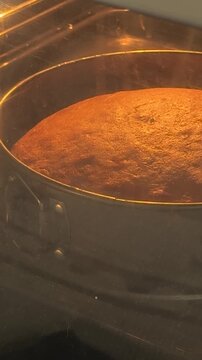 Golden brown cake baking inside oven