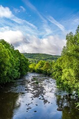 Obraz premium Beautiful Mountain River Flowing Through Green Summer Forest and Hills