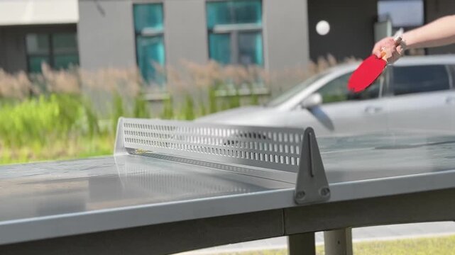 Table tennis ball flying over the net during an outdoor ping pong game