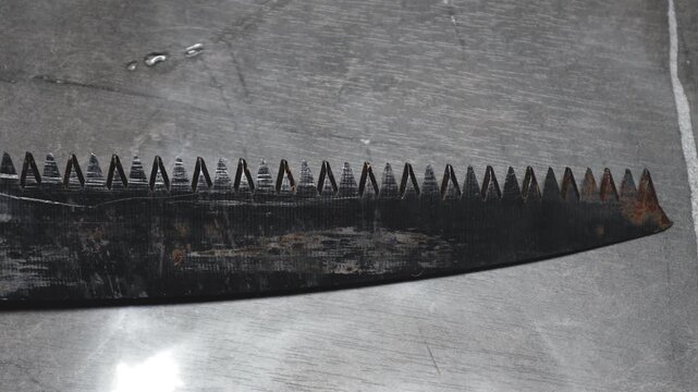A close-up shot of a metal blade on a table, suitable for use in product photography or as a design element