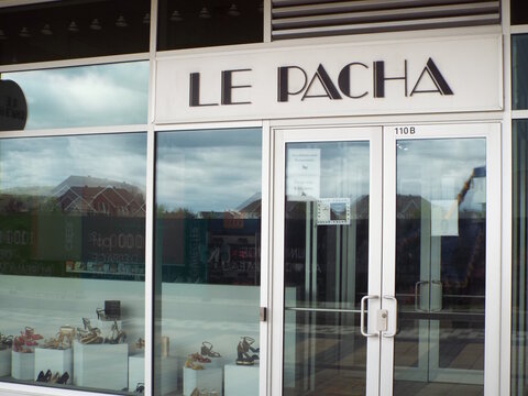 Gatineau, Quebec, Canada &ndash; May 12, 2026: The "Le Pacha" storefront displays various shoes in the window behind a glass entrance at a commercial plaza at 35 All&eacute;e de Hambourg.
