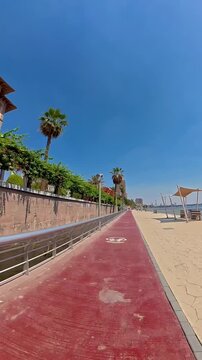 A wide-angle, sunlit shot of the dedicated cycling track and pedestrian promenade located along the Nile River in the Zamalek district, Cairo, Egypt. The footage captures the clean architectural lines
