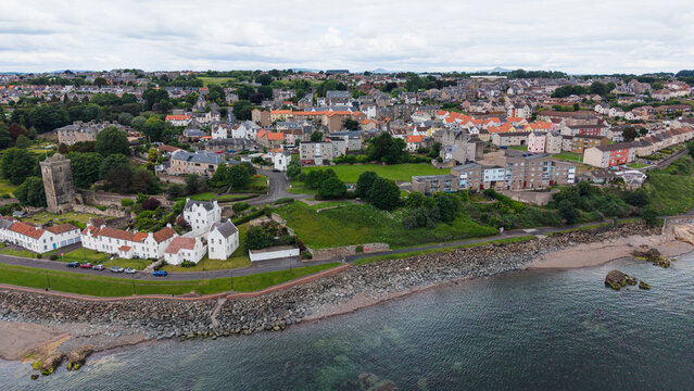 Panoramic view of Dysart coastal village with traditional houses, historic tower, and the coastline of Firth of Forth in Fife, Scotland.
