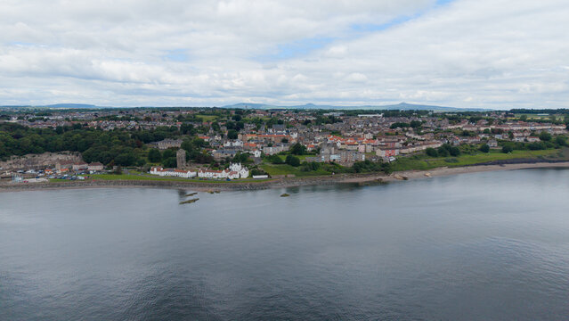 Wide aerial panoramic view of Dysart coastal townscape stretching along the Firth of Forth shoreline in Fife, Scotland.