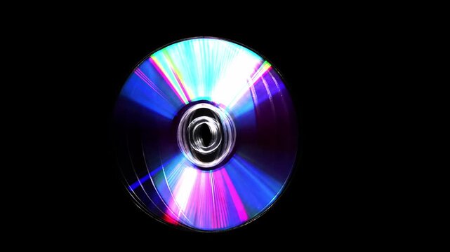 a rotating CD and DVD discs showcasing vibrant rainbow-like colors. Brilliant rainbow diffraction patterns shimmer across the metallic surfaces, creating vivid colors and holographic reflections