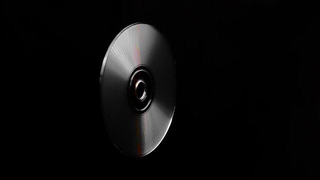 a rotating CD and DVD discs showcasing vibrant rainbow-like colors. Brilliant rainbow diffraction patterns shimmer across the metallic surfaces, creating vivid colors and holographic reflections