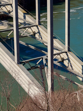 View of a bridge spanning a river with strong support structures and clear waters observed from an elevated angle during daylight hours
