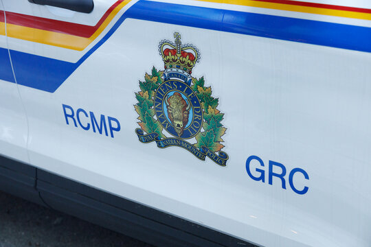 A close view of the full-colour RCMP crest, its crown, bison and MAINTIENS LE DROIT motto flanked by RCMP and GRC lettering on a marked police door.
