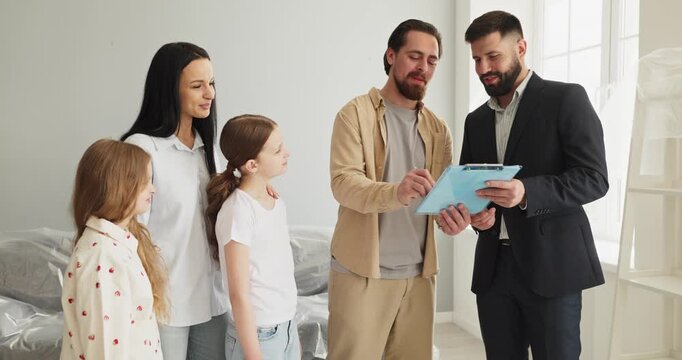 Family with mother father daughters meets agent. Happy parents signing papers in a bright house while children watch, signaling moving plus relocation. Concept highlights new home purchase