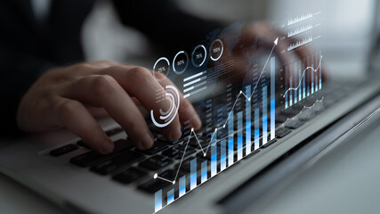 Modern Businessman Analyzing Financial Data on Laptop with Visual Analytics Overlay on Keyboard in Innovative Office Environment. Bitwise. © InfiniteFlow