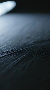 Vertical video: Entering focused LED head casting beam onto tabletop revealing grooves and dust