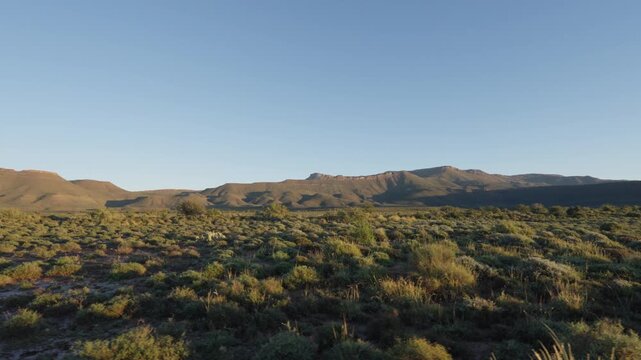 4K 30fps tracking footage of the stunning Nama-Karoo landscape near Beaufort West, Western Cape, South Africa, featuring vast semi-arid plains, rugged terrain and pristine natural scenery.