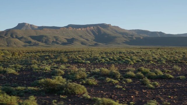 4K 30fps tracking footage of the stunning Nama-Karoo landscape near Beaufort West, Western Cape, South Africa, featuring vast semi-arid plains, rugged terrain and pristine natural scenery.
