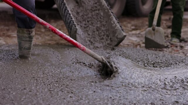 Pouring concrete from mixer truck chute during foundation construction