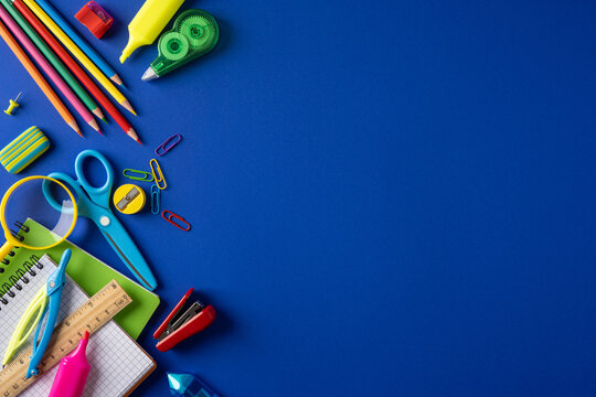 Colorful school supply items arranged on a blue background