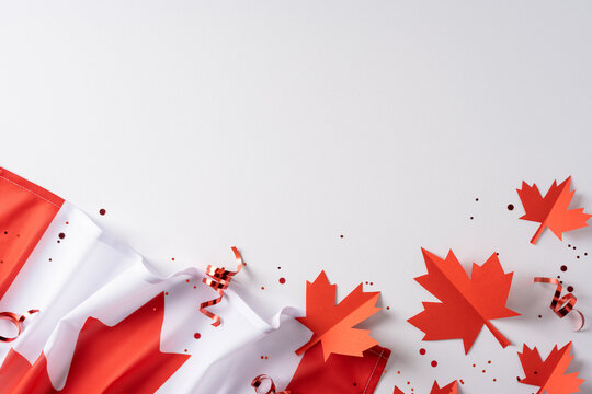 Canada Independence Day celebration with maple flag, paper leaves and confetti on white background
