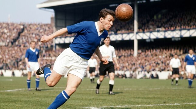 Vintage photograph of a football player in action during a match, heading the ball. He is wearing a blue jersey and white shorts, with spectators in the background