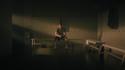 Fototapeta premium Athlete with Bionic Leg Sitting in Beam of Light. Man Transitions From Pensive Look Toward Window to Sharp, Inspired, and Strong Expression. Intersection of Vulnerability and Empowerment. Portrait.