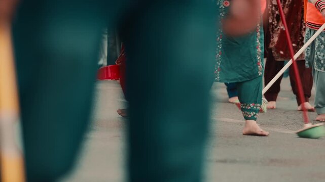 Crowd of Indian religious women clean the road for the Sikh guru