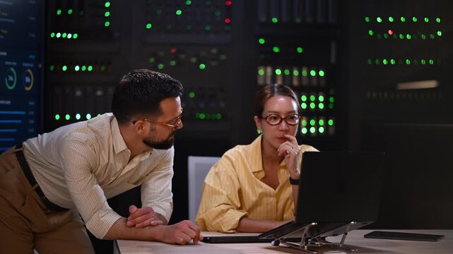 It professionals collaborating on network administration and server maintenance in a modern data center server room