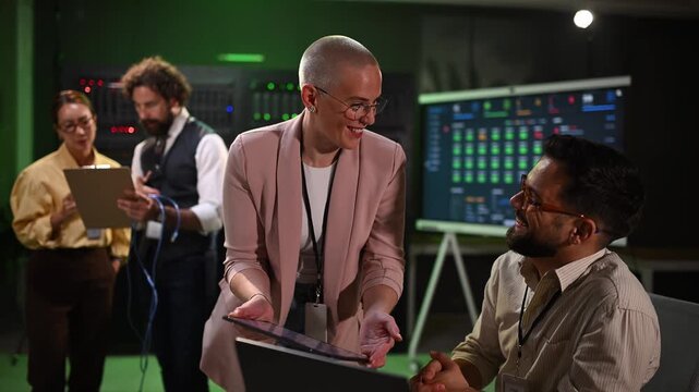 Professionals discussing network performance and database management in a server room. It technicians collaborating on diagnostics and analytics
