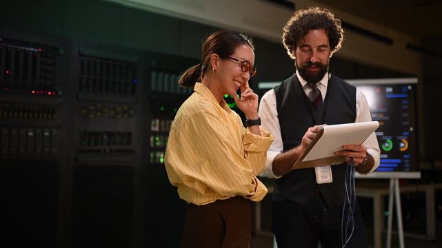 It engineers laughing and collaborating while checking servers in a modern data center control room, ensuring optimal performance