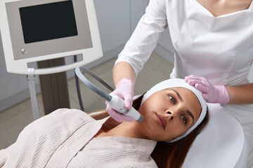 Naklejka premium Face Skin Care. Close-up Of Woman Getting Facial Hydro Microdermabrasion Peeling Treatment At Cosmetic Beauty Spa Clinic. Hydra Vacuum Cleaner. Exfoliation, Rejuvenation And Hydratation