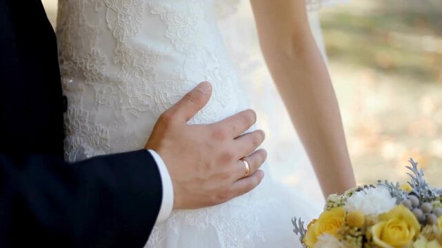 Groom touch his bride on waist and hip sensually close up.