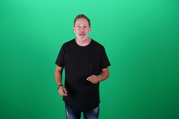 Fototapeta premium Real people. Man at his 50s, Medium shot, isolated on green screen in various poses and facial expressions. Studio capture with clean chroma key background, ideal for compositing
